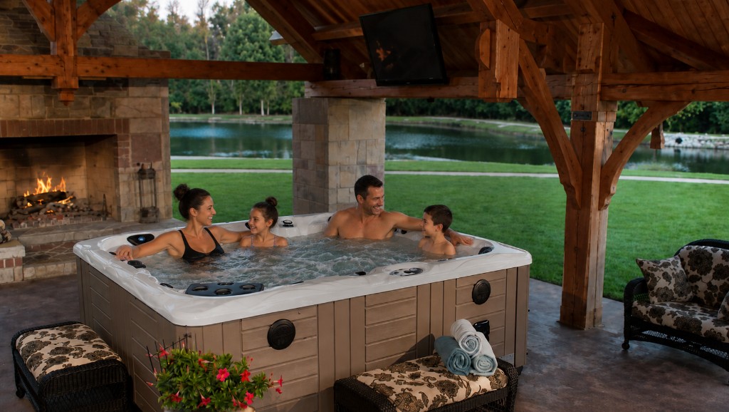 Family relaxing in a hot tub at sunset